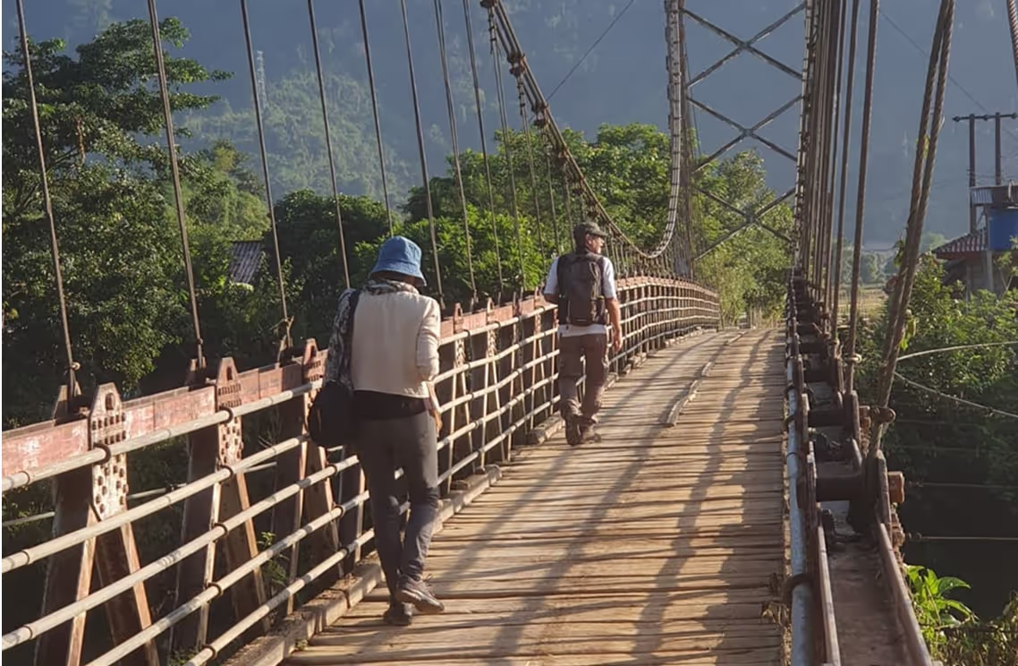 People crossing a bridge in Van Vieng, Laos